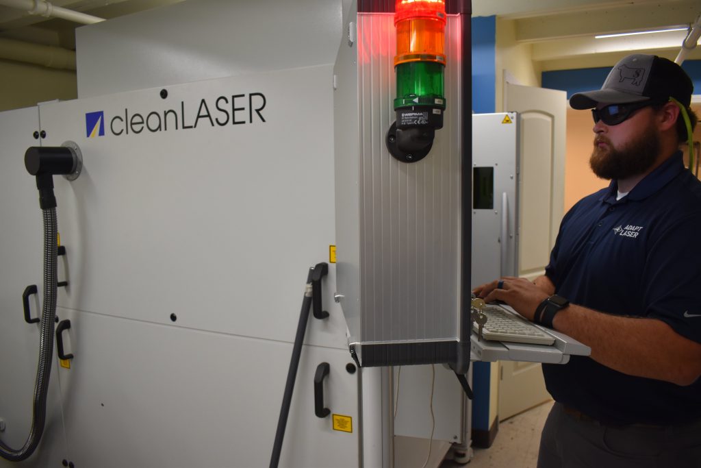 service tech stands at keypad in front of large Cleancell laser