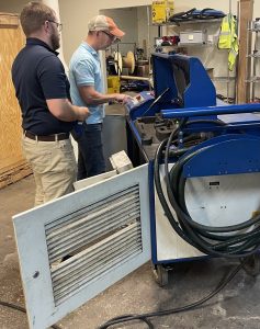 two men servicing a laser cleaning system