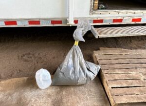 A plastic bag tied up with 40 lbs of waste inside